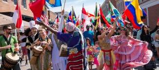 在一年一度的2015国际街头集市上，参与者跳舞，挥舞着他们国家的国旗.